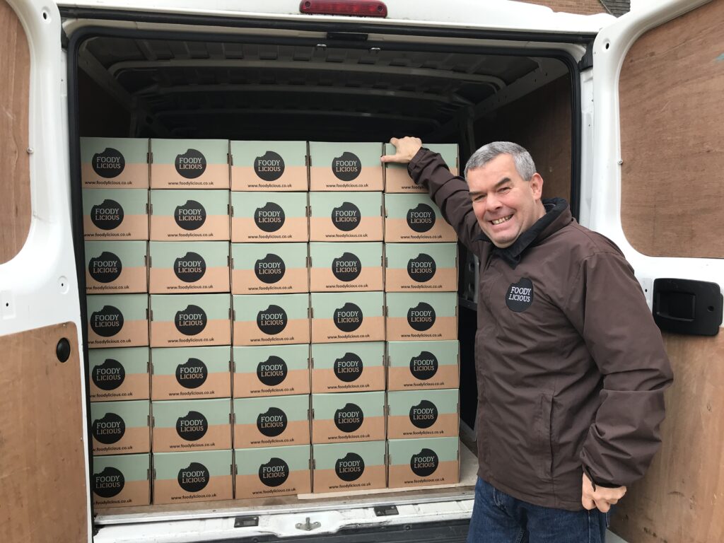Foodylicious founder Simon standing in front of a van full of Foodylicious boxes