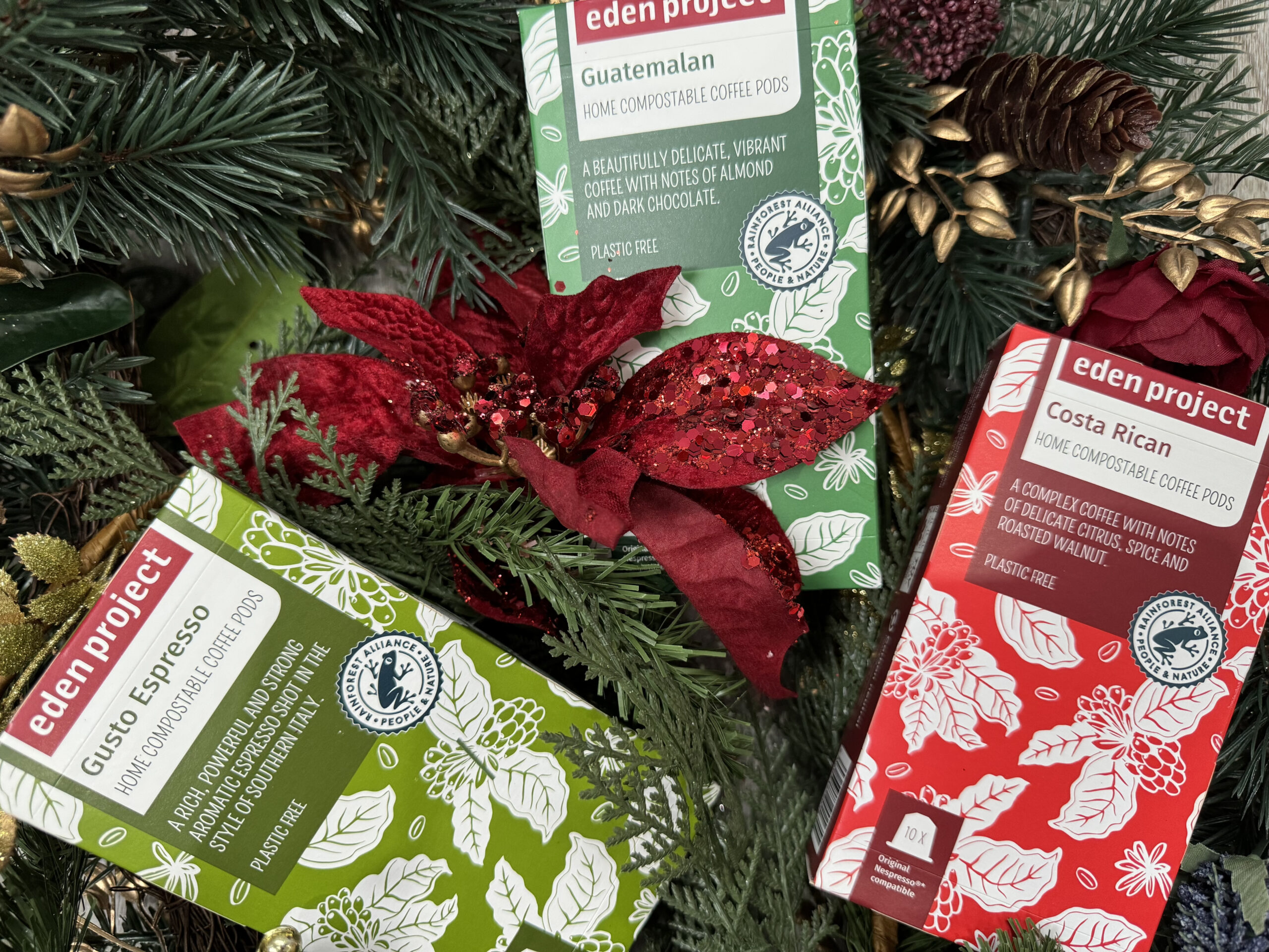 Three boxes of coffee pods on a festive background